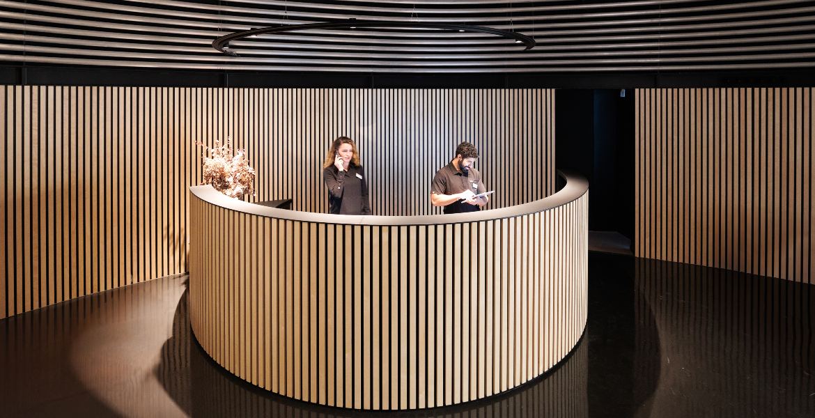 Réception moderne à l’entrée de la clinique Barcelona IVF avec des collaborateurs prêts à accueillir les patients.