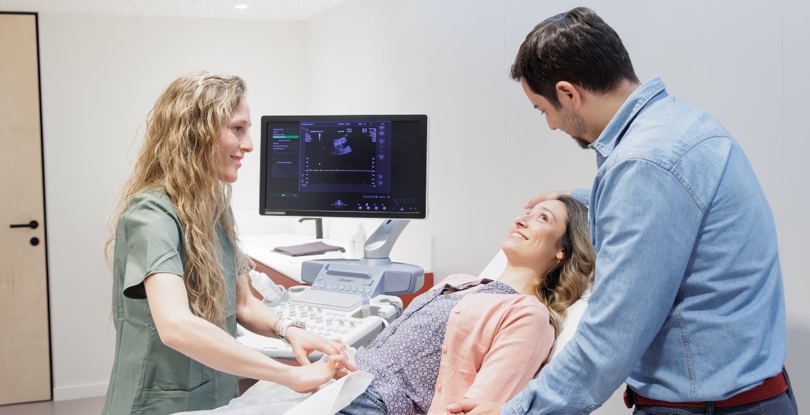 Un couple accompagne une patiente lors d’un examen échographique médical réalisé par une spécialiste à la clinique Barcelona IVF.