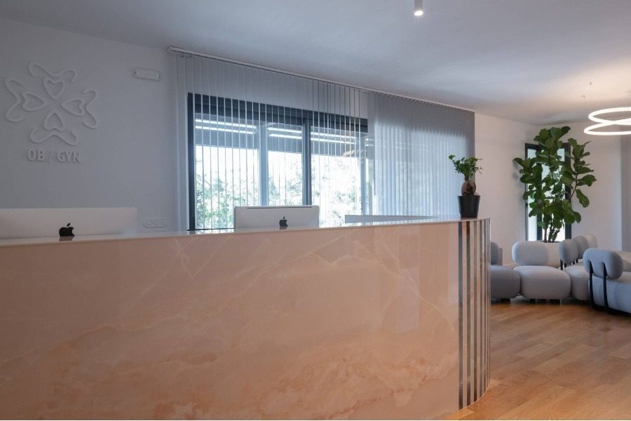 Bureau d’accueil moderne et salle d’attente chaleureuse de la clinique FIV Ovagenesis à Athènes