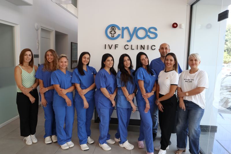 Photo de groupe du personnel médical et des coordinateurs de la clinique Cryos IVF Chypre, posant devant le logo de la clinique. Cette équipe de spécialistes de la fertilité est dédiée aux soins des patients à Nicosie, Chypre.